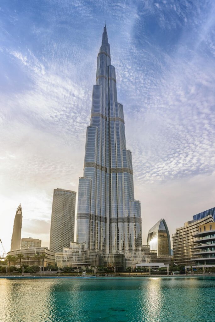 Majestic Burj Khalifa against a bright blue sky reflecting in water, Dubai.